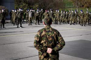 (FILES) In this file photo taken on November 8, 2020 Swiss army reservists listen to officers speeches at Moudon military base before being deployed to support public hospitals in the battle against the second wave of Covid-19 caused by the novel coronavirus. - To reduce the risk of Covid-19 spreading in its barracks, the Swiss army decided that several thousand of its recruits would start their military service at home. (Photo by Fabrice COFFRINI / AFP)
