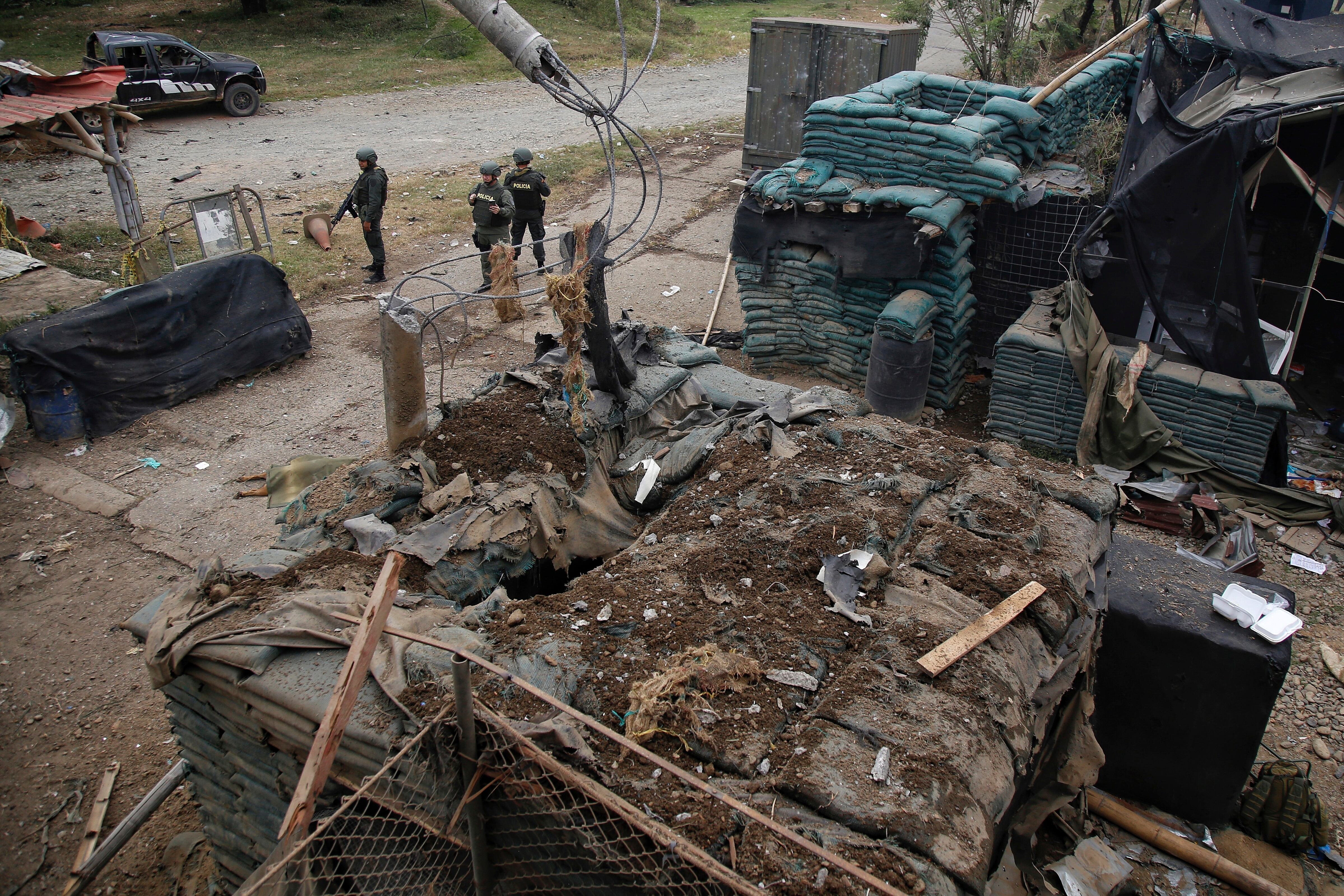 Police stand guard before a damaged police station after a car bomb exploded, in Timba, Cauca, Colombia, Sunday, Aug. 13, 2023. According to police, the car bomb killed one police officer. (AP Photo/Andres Quintero)