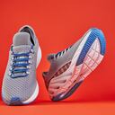 Stability and cushion running shoes. New unbranded running sneaker or trainer on orange background. Men's sport footwear. Pair of sport shoes.