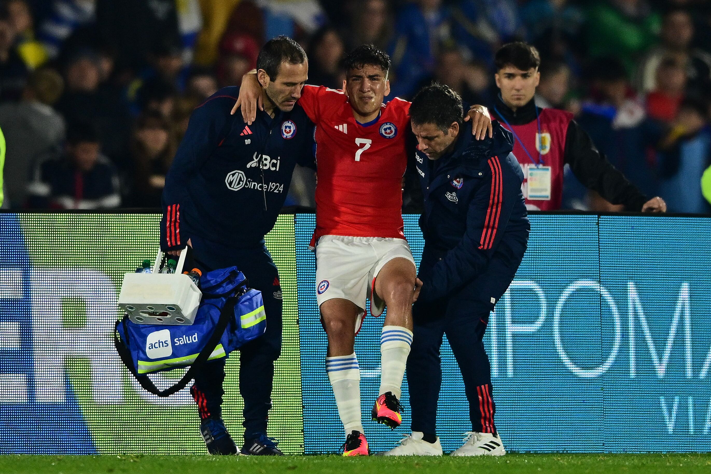 Chile's midfielder Marcelino Nu�ez is assisted during the 2026 FIFA World Cup South American qualifiers football match between Uruguay and Chile, at the Centenario stadium in Montevideo, on September 8, 2023. (Photo by Pablo PORCIUNCULA / AFP)