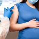 Vacunación para embarazadas. Mujer embarazada en mascarilla vacunarse en la clínica. Doctor dando paciente de inyección de vacuna contra el virus Corona. Protección contra la influenza Covid-19. Enfoque selectivo.