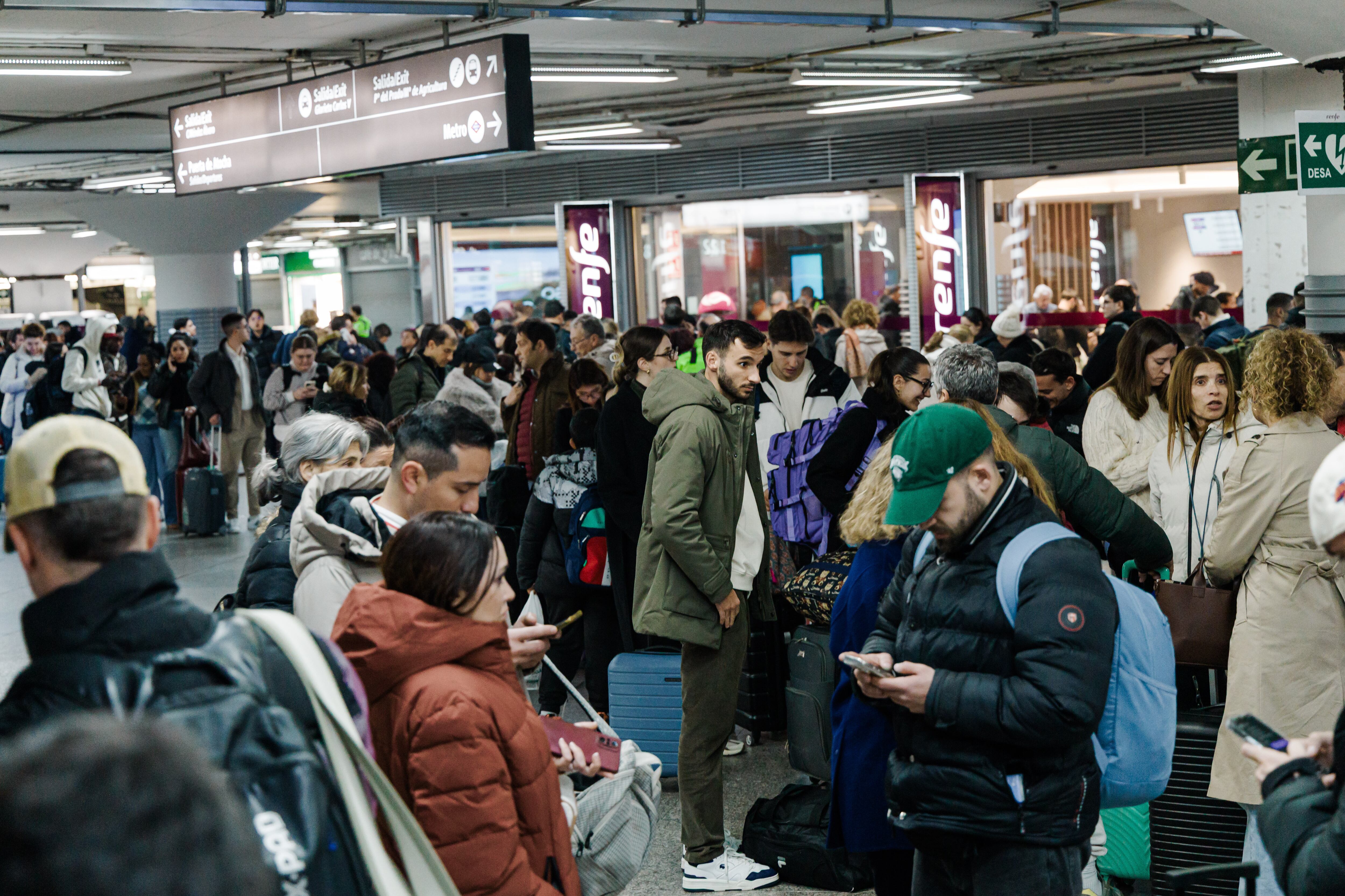 Pasajeros esperan en el vestíbulo de la estación de trenes de Madrid, el domingo 18 de enero de 2026, tras el anuncio de la suspensión del servicio debido al descarrilamiento de dos trenes en Córdoba. (Carlos Luján/Europa Press vía AP)