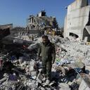 Un sobreviviente del terremoto sobre los escombros de su hogar dañado en la ciudad de Jandaris, Siria.