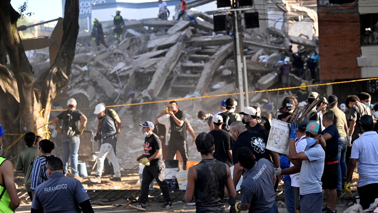 Voluntarios y rescatistas buscan sobrevivientes entre los escombros de un edificio derrumbado tras el terremoto en Cali, Colombia, el 11 de agosto de 2026.