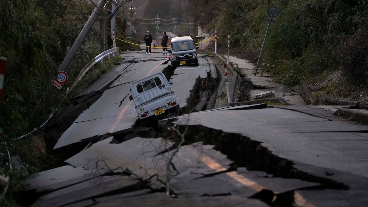 Los transeúntes observan los daños cerca de la ciudad de Noto en la península de Noto frente al Mar de Japón, al noroeste de Tokio, el martes 2 de enero de 2024