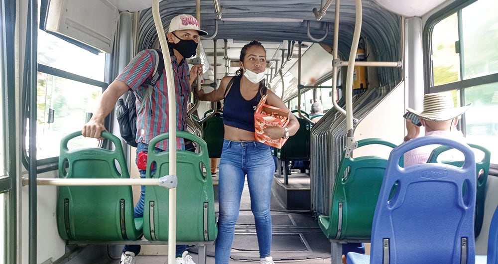  Alan Santos perdió su empleo hace tres semanas. Aunque tiene experiencia en vigilancia y seguridad privada no ha conseguido trabajo. Vende golosinas en los buses de Metrolínea para poder llevar algo a su familia: tres hijos y su esposa. En la imagen lo acompaña Naillu Galeno, una joven venezolana que empezó a rebuscarse con estas ventas. 