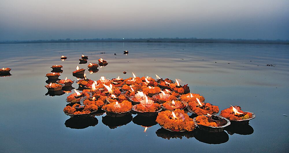 Sobre las aguas sagradas del Ganges, que conducen al paraíso, flotan lámparas con pétalos azafranados de flores