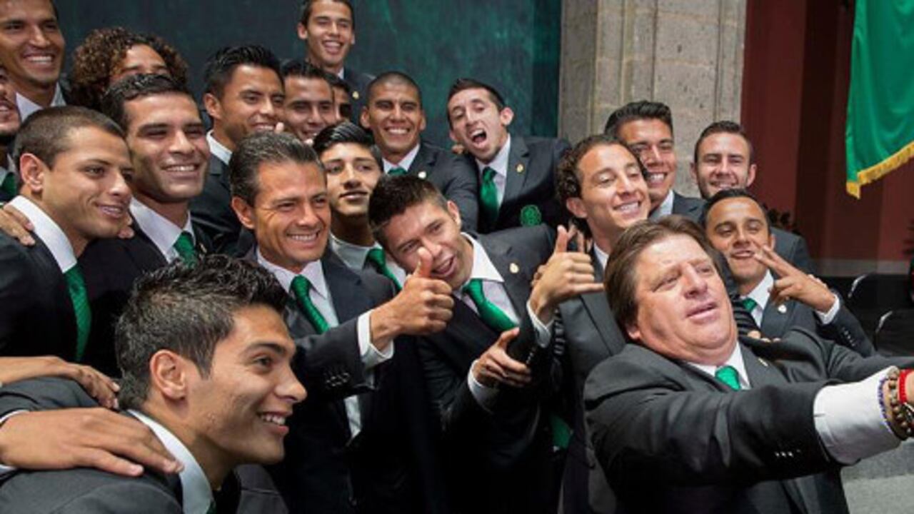 El presidente mexicano Enrique Peña Nieto (c-i) posa para una fotografía con los jugadores y el director técnico de la selección mexicana de fútbol, Miguel Herrera (d-frente).