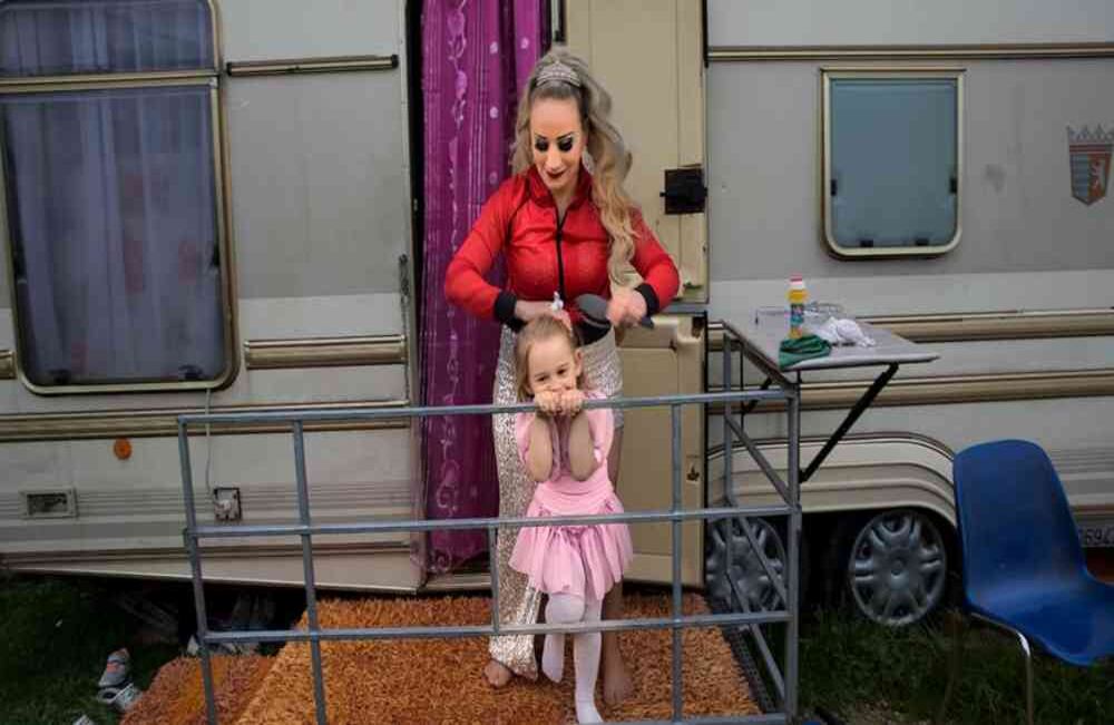 Anamaria Bud cepilla a su hija Maria Cristina afuera de su caravana en el Circo Romina Orfei, estacionado en San Nicola la Strada, cerca de Nápoles, Italia.  AP-Alessandra Tarantino