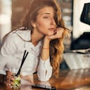 Bored woman drinking cocktail at a bar.