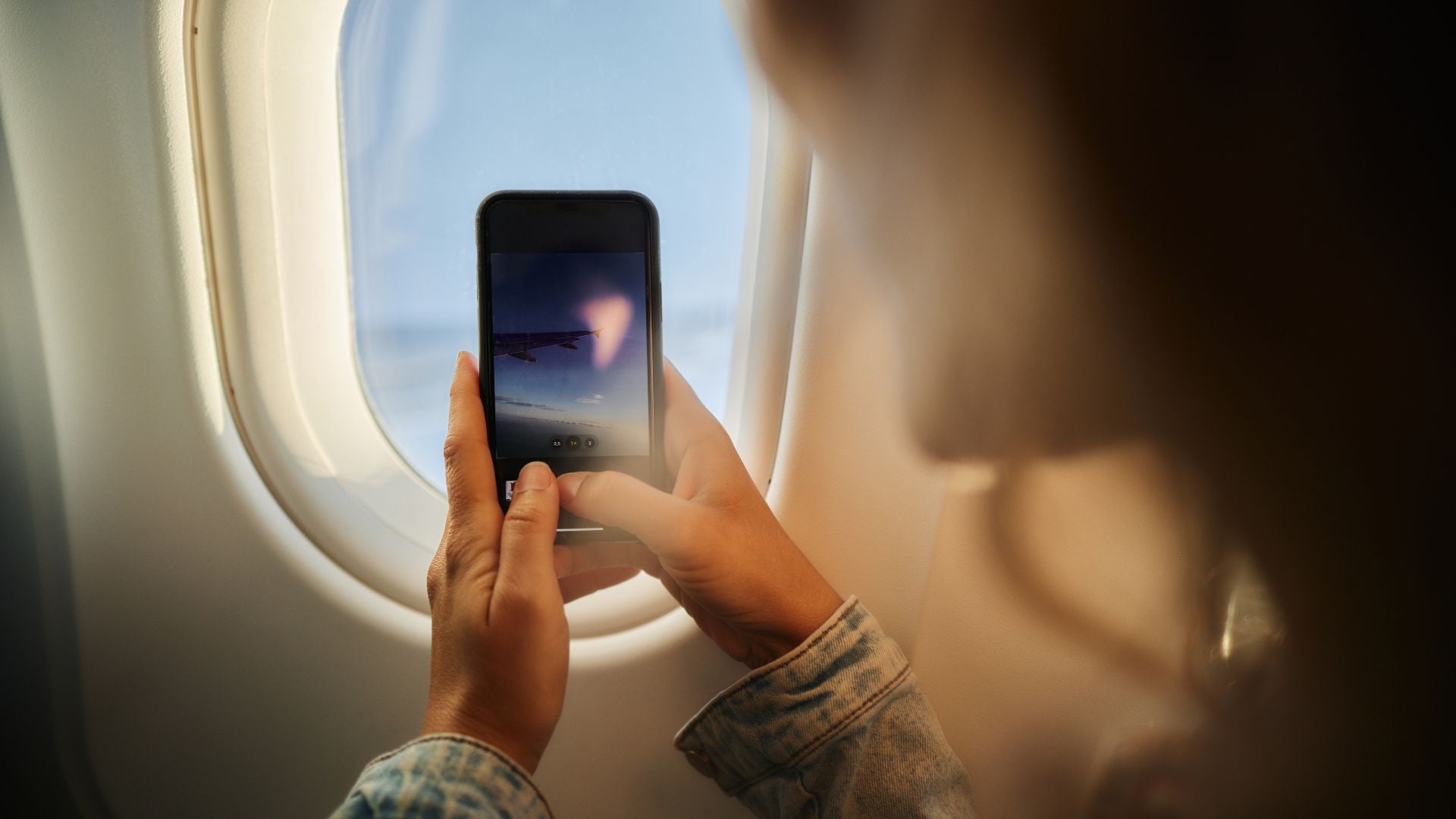 Imagen de referencia de persona tomando fotos desde el avión.