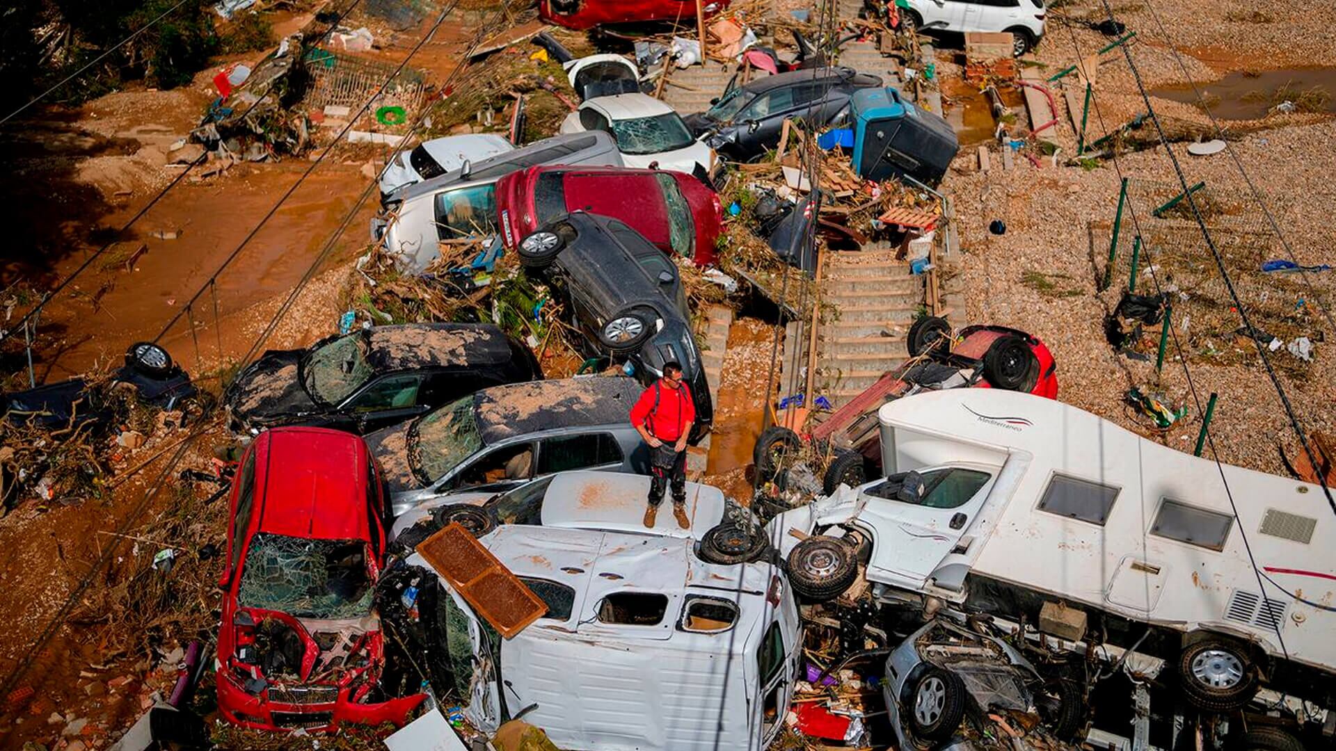 Un hombre se encuentra entre autos amontonados en Valencia, España, tras las inundaciones del jueves 31 de octubre de 2024.