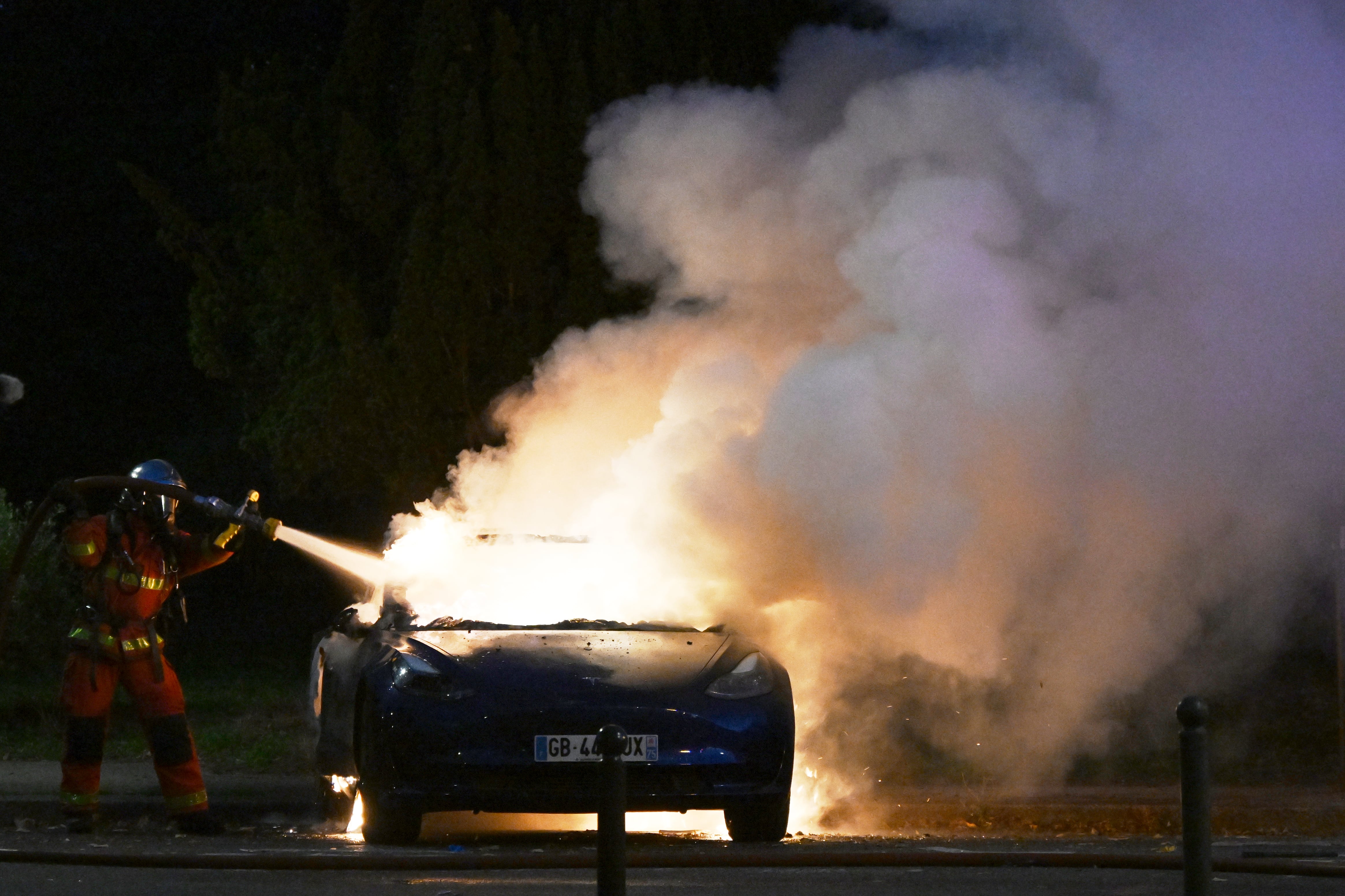Un automóvil arde durante unas protestas por el costo de vida y la educación en París, Francia.