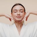 Young woman doing face building facial gymnastics self massage