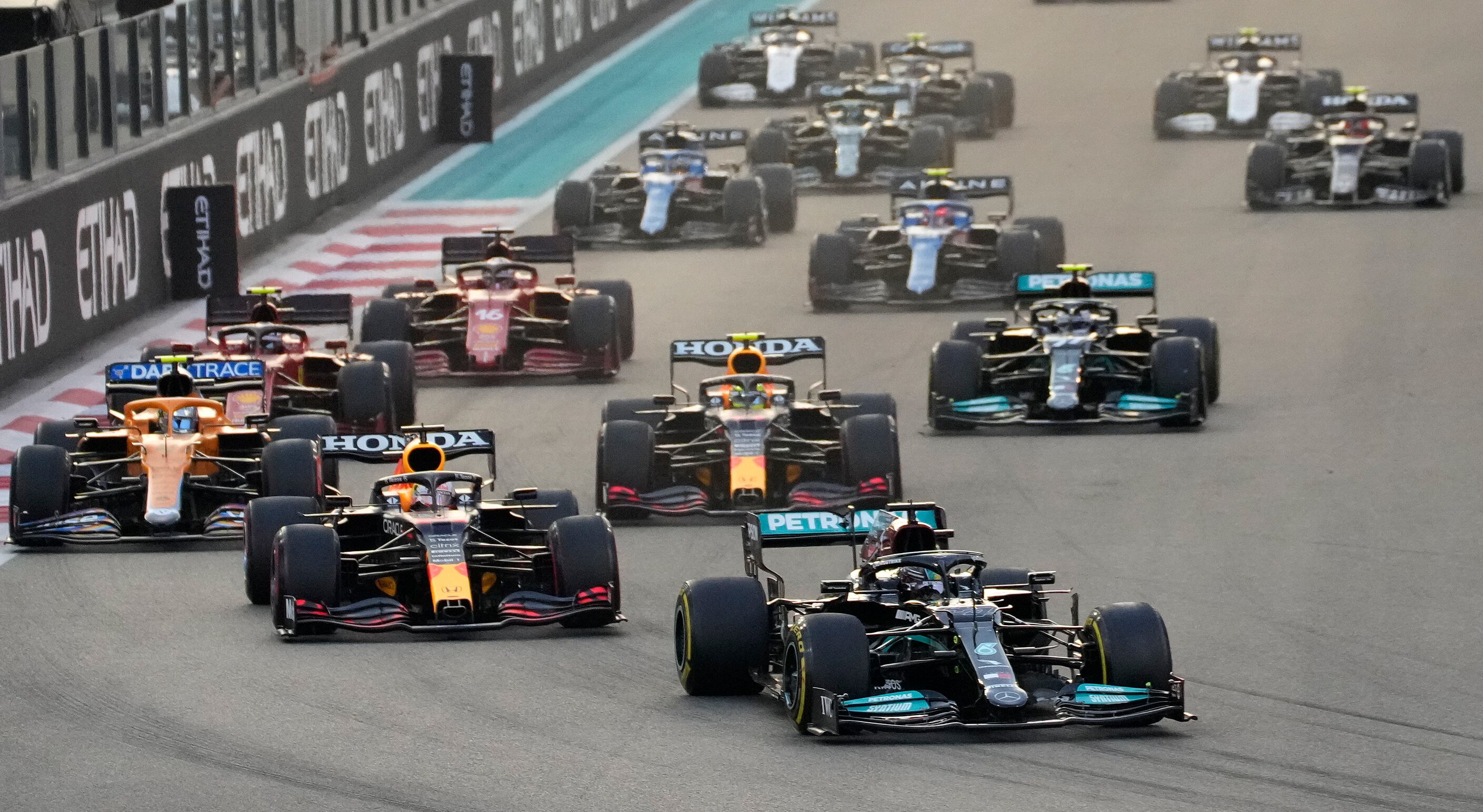 Mercedes driver Lewis Hamilton of Britain in leads Red Bull driver Max Verstappen of the Netherlands at the start of the Formula One Abu Dhabi Grand Prix in Abu Dhabi, United Arab Emirates, Sunday, Dec. 12. 2021. Max Verstappen ripped a record eighth title away from Lewis Hamilton with a pass on the final lap of the Abu Dhabi GP to close one of the most thrilling Formula One seasons in years as the first Dutch world champion. (AP Photo/Hassan Ammar)