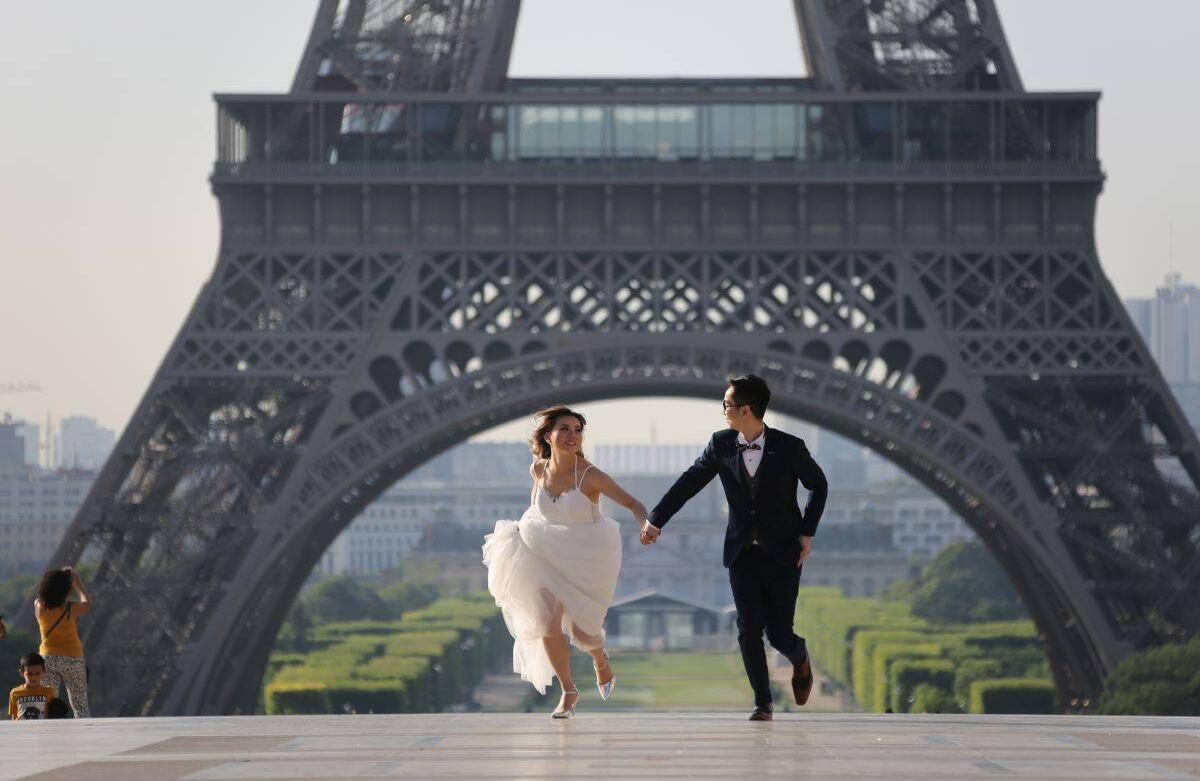 Un joven matrimonio se ejecuta en la plaza de Trocadero frente a la Torre Eiffel el 4 de julio de 2017 en París. / AFP PHOTO / LUDOVIC MARIN
