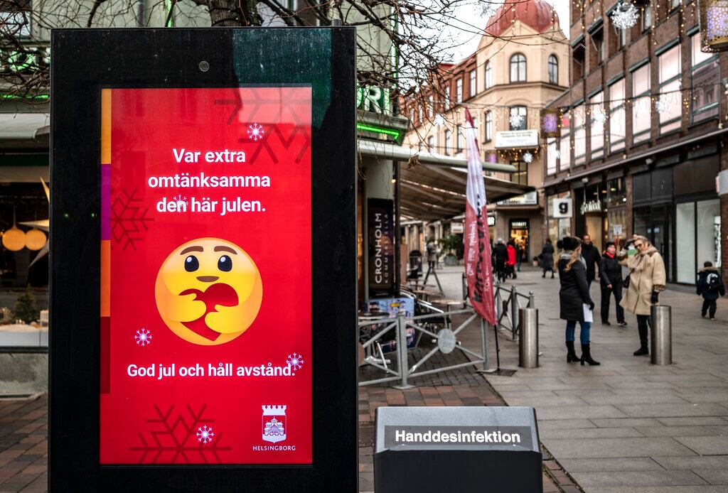 An public information sign wishing Merry Christmas and asking to maintain social distancing is seen in a pedestrian shopping street in Helsingborg, southern Sweden, on Monday Dec. 7, 2020. The last week in November, Helsingborg had more new confirmed Covid-19 cases than in any other city in Sweden, according to official figures. (Johan Nilsson / TT via AP)