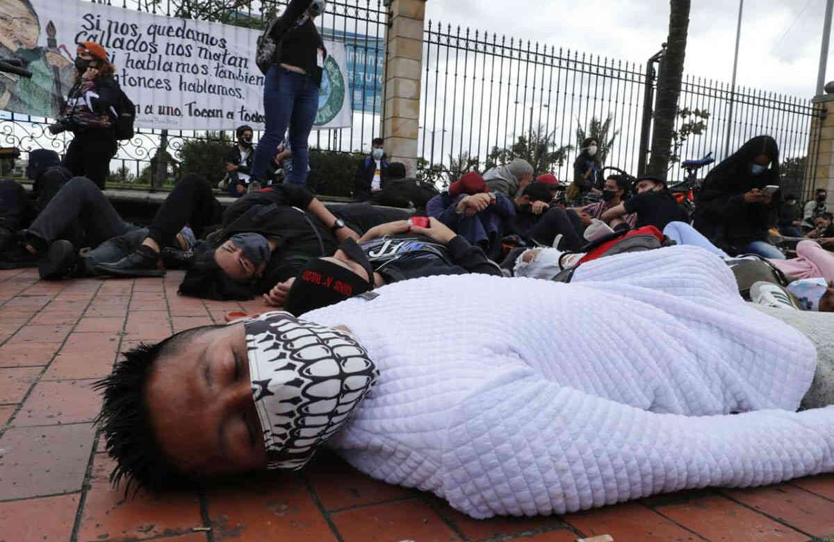 Un joven con tapabocas se tiende en el suelo en señal de protesta por las recientes muertes a causa de las masacres y el aumento de la violencia en el país. Foto Guillermo Torres / Semana