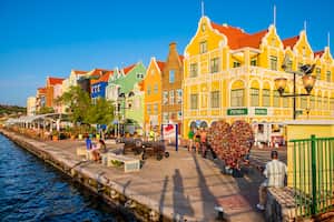 Turistas en el hermoso paseo marítimo de Punda en Willemstad, la capital de Curazao, una isla en el sur del mar Caribe.