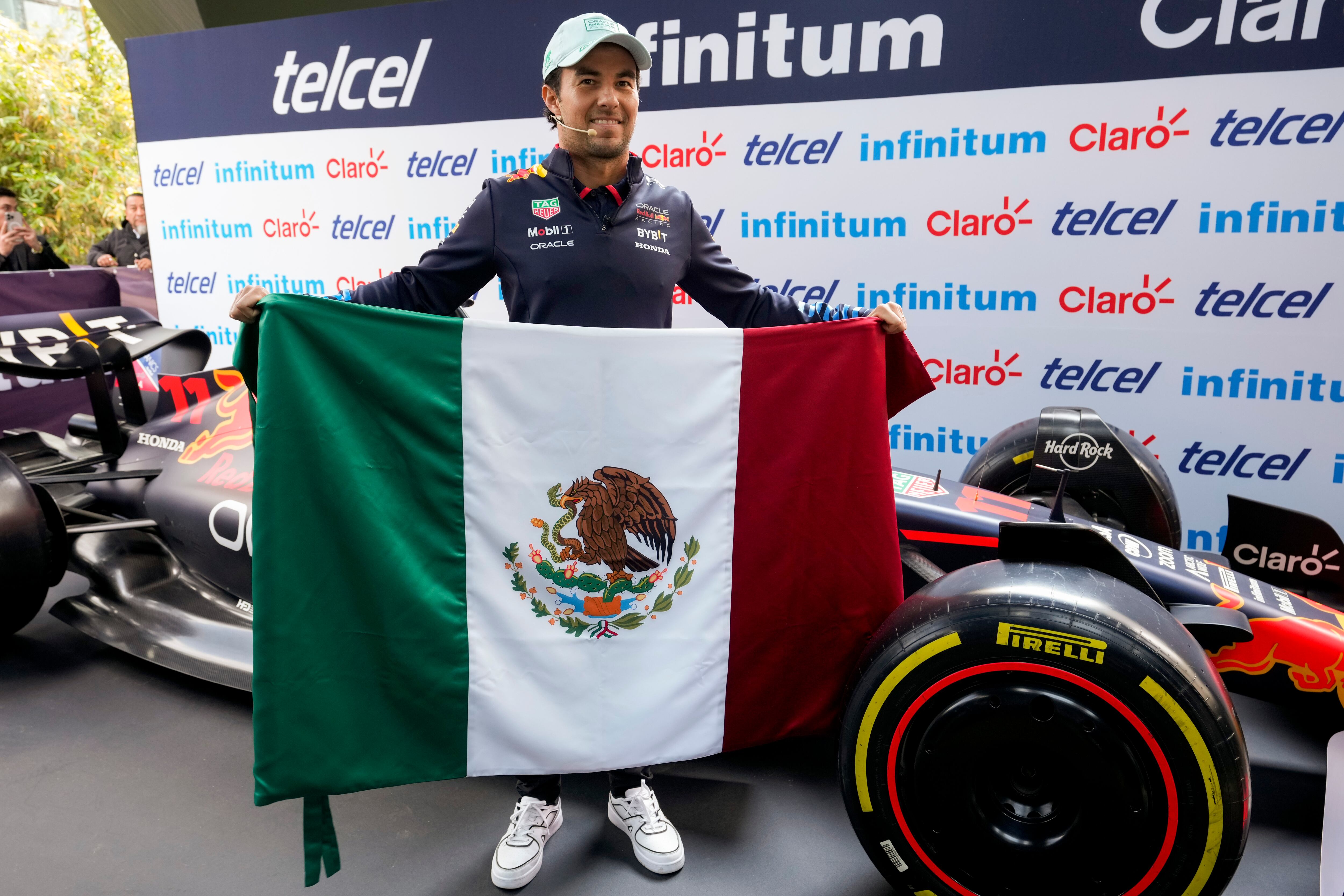 El piloto mexicano de Red Bull Sergio Pérez sostiene una bandera de México durante su conferencia de prensa antes del Gran Premio de México el miércoles 23 de octubre del 2024. (AP Foto/Moises Castillo)