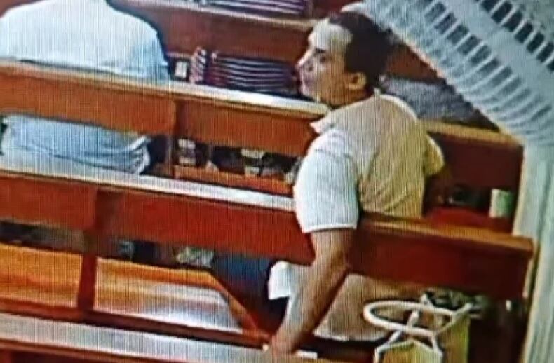 Hombre robando pertenencias de una mujer en una iglesia