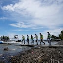 Migrantes haitianos caminan hacia los barcos que los llevarán de Necoclí a Acandi, Colombia, cerca de la frontera con Panamá, el lunes 13 de septiembre de 2021. Los migrantes se han estado aglomerando en Necoclí a medida que avanzan en su ruta hacia el norte del continente como parte de un masivo flujo irregular que incluye el cruce por la peligrosa jungla del Darién. (Foto AP/Fernando Vergara)
