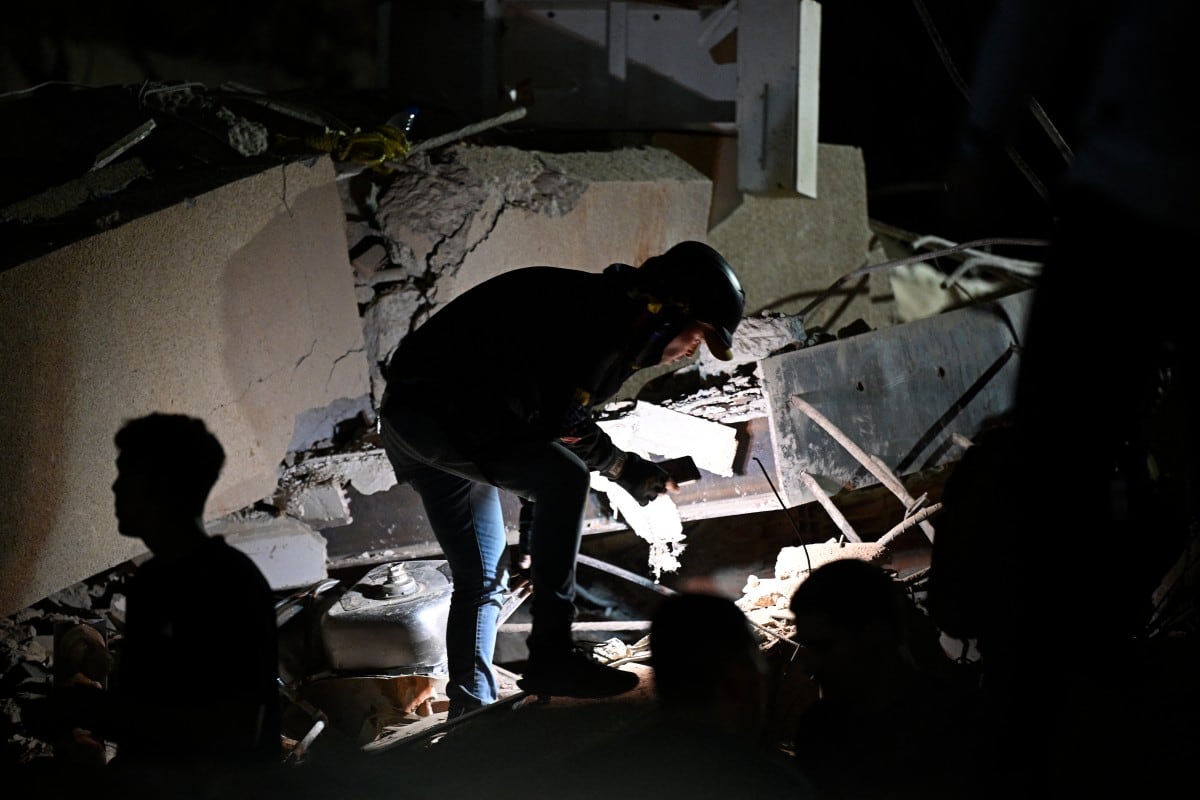 Un rescatista busca entre los escombros de un edificio derrumbado tras el terremoto que sacudió Caracas el 24 de junio de 2026.