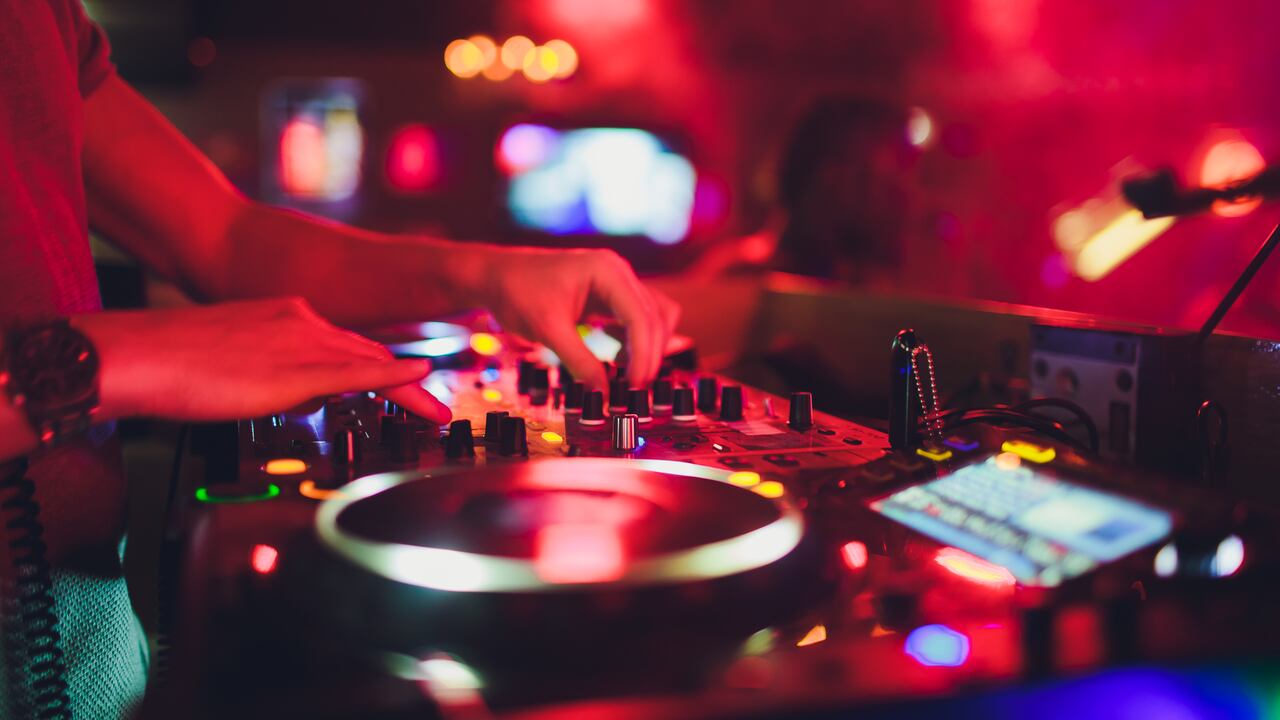DJ hands on the remote. nightclub. DJ controlling and moving the mixers in music remote