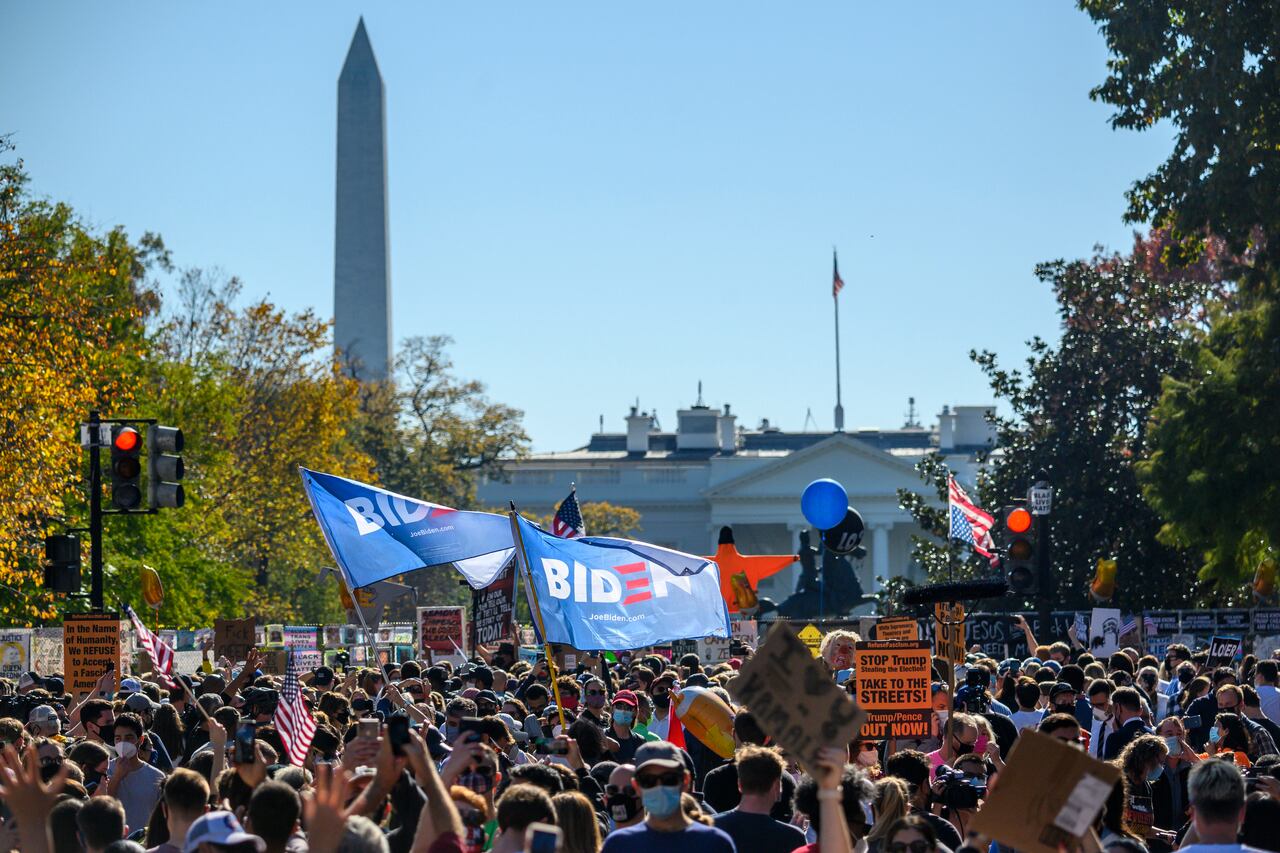 La gente celebra en la plaza Black Lives Matter frente a la Casa Blanca en Washington, DC el 7 de noviembre de 2020, después de que Joe Biden fuera declarado ganador de las elecciones presidenciales de 2020. - El demócrata Joe Biden ganó la Casa Blanca, dijeron los medios estadounidenses el 7 de noviembre, derrotando a Donald Trump y poniendo fin a una presidencia que convulsionó la política estadounidense, conmocionó al mundo y dejó a Estados Unidos más dividido que en cualquier otro momento en décadas. (Foto de Eric BARADAT / AFP)