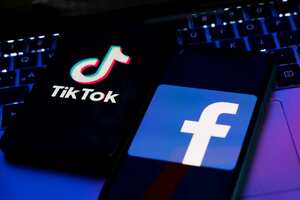 TikTok and Facebook logos displayed on phone screens and a laptop keyboard are seen in this illustration photo taken in Krakow, Poland on February 6, 2022. (Photo illustration by Jakub Porzycki/NurPhoto via Getty Images)