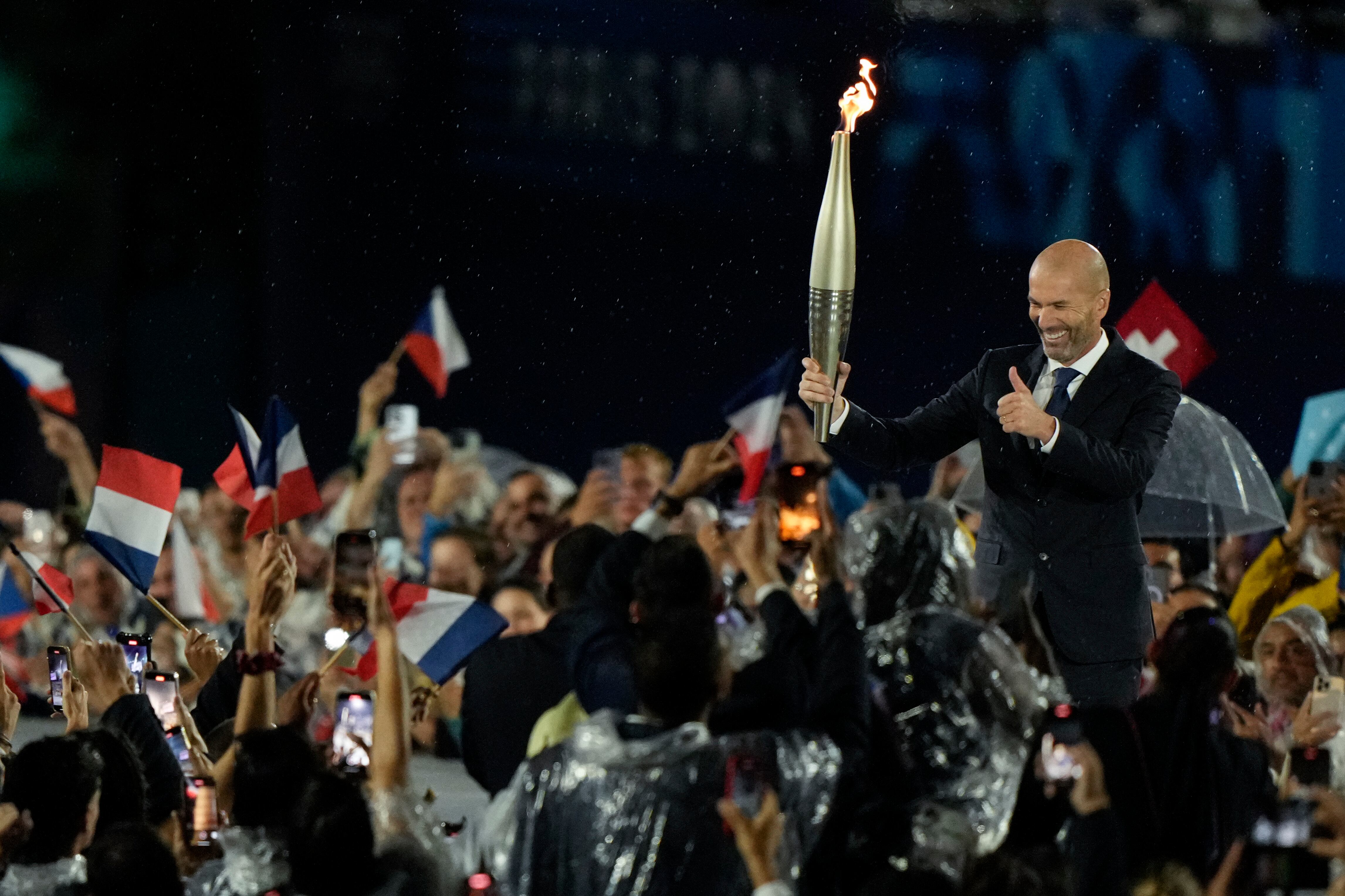 Zinedine Zidane traslada la llama olímpica durante la ceremonia de inauguración de los Juegos Olímpicos de París.