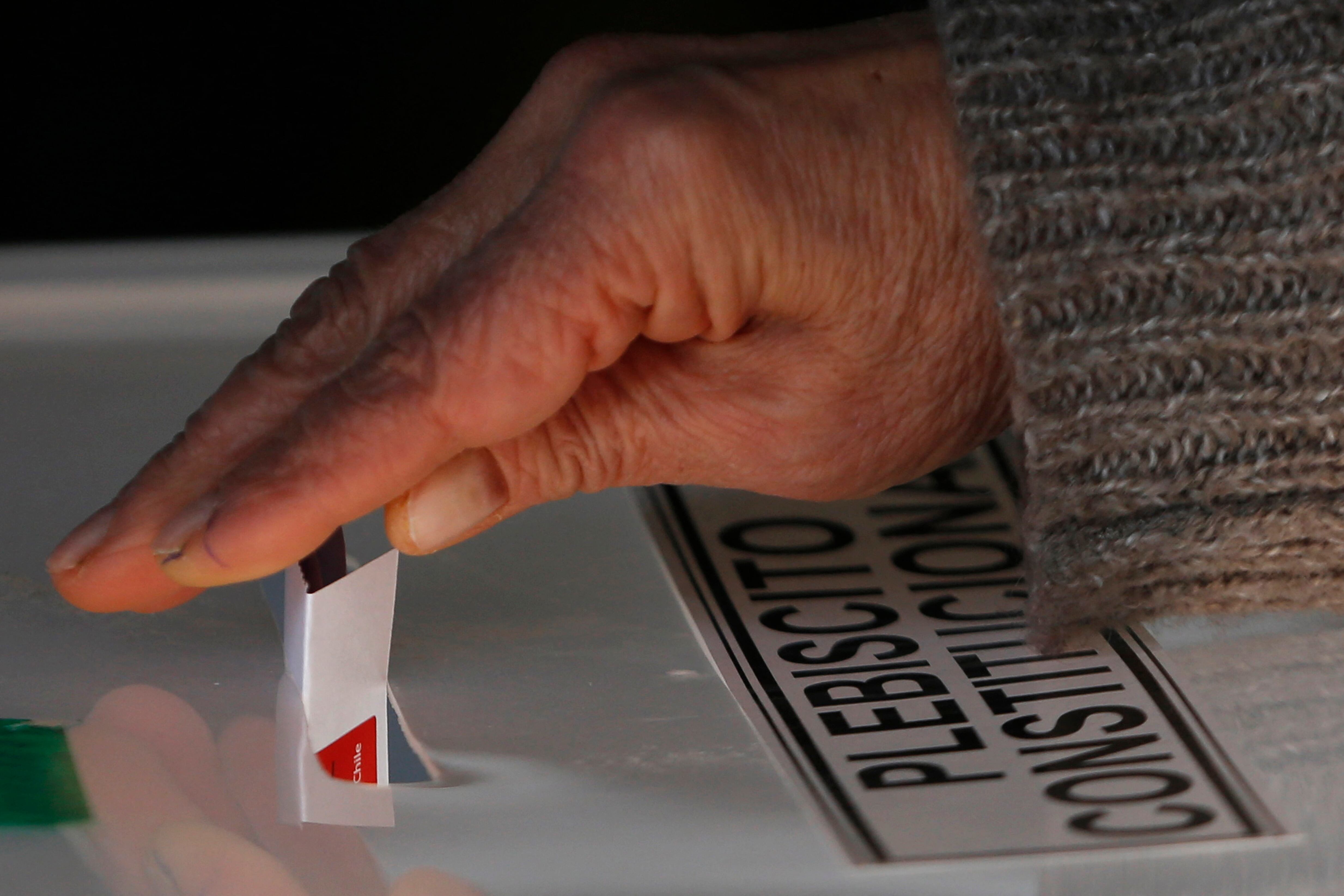 Una mujer emite su voto durante un referéndum para aprobar o rechazar una nueva Constitución en un colegio electoral de Santiago, el 4 de septiembre de 2022. - Más de 15 millones de votantes comenzaron este domingo a votar en Chile para aprobar o rechazar una nueva Constitución que sustituir al heredado de la dictadura de Augusto Pinochet (1973-1990). (Foto de CLAUDIO REYES / AFP)