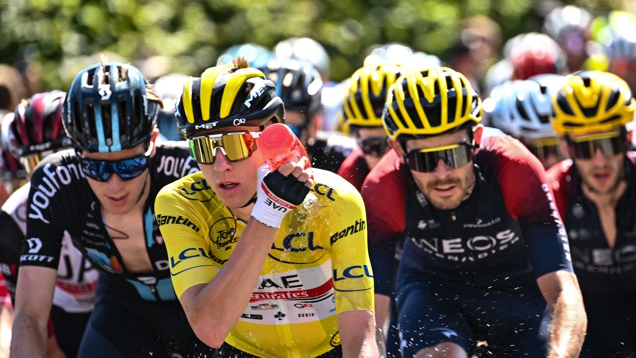 UAE Team Emirates team's Slovenian rider Tadej Pogacar wearing the overall leader's yellow jersey cools down with water as he cycles with the pack of riders during the 10th stage of the 109th edition of the Tour de France cycling race, 148,1 km between Morzine and Megeve, in the French Alps, on July 12, 2022. (Photo by Marco BERTORELLO / AFP)