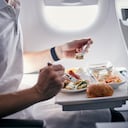 Pasajero comiendo comida de avión. Imagen de referencia