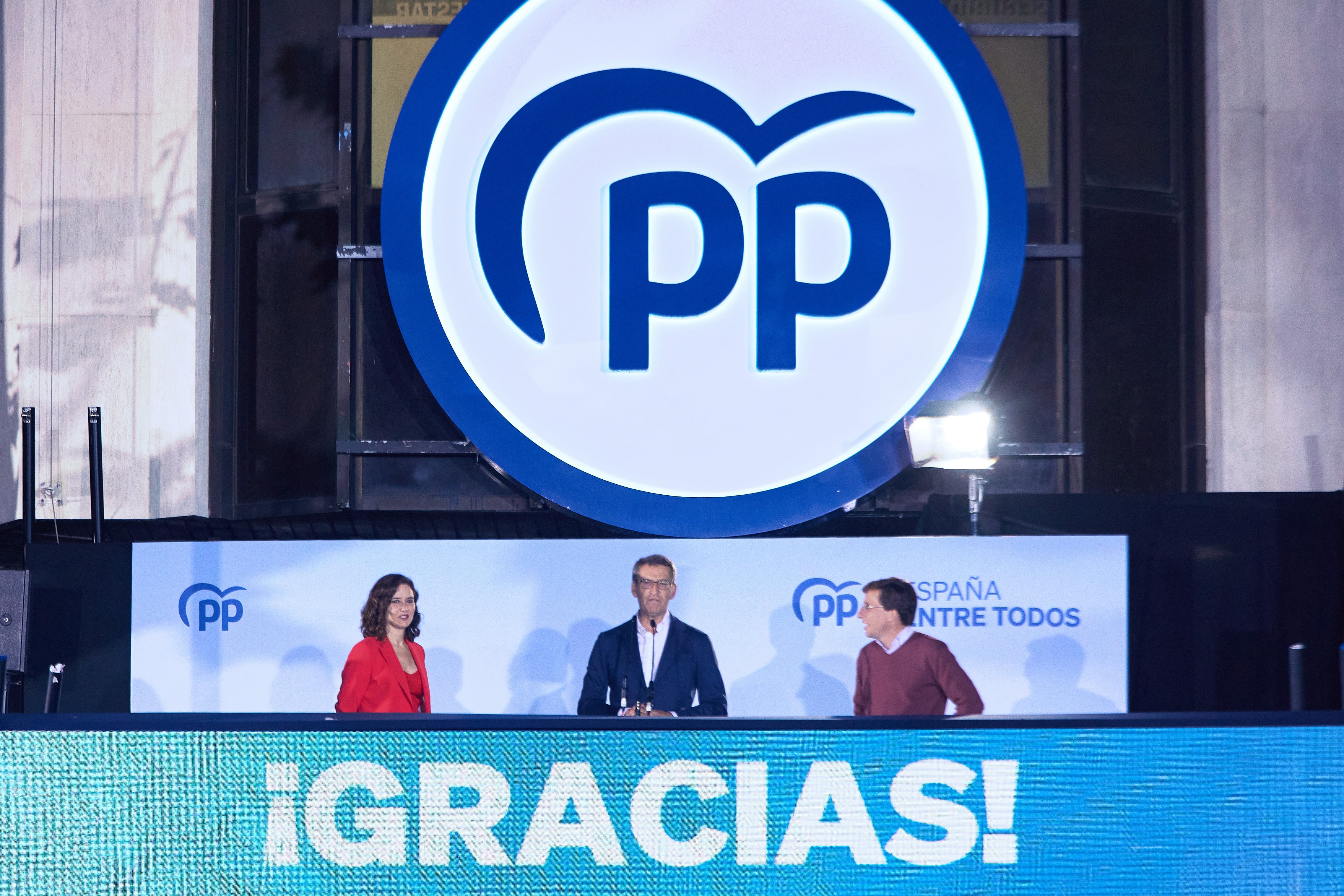 La presidenta de la Comunidad de Madrid y candidata a la reelección, Isabel Díaz Ayuso; el líder del Partido Popular, Alberto Núñez Feijoo, y el alcalde de Madrid y candidato a la reelección, José Luis Martínez-Almeida, celebran la victoria del partido en la sede nacional del PP, el 28 de mayo de 2023