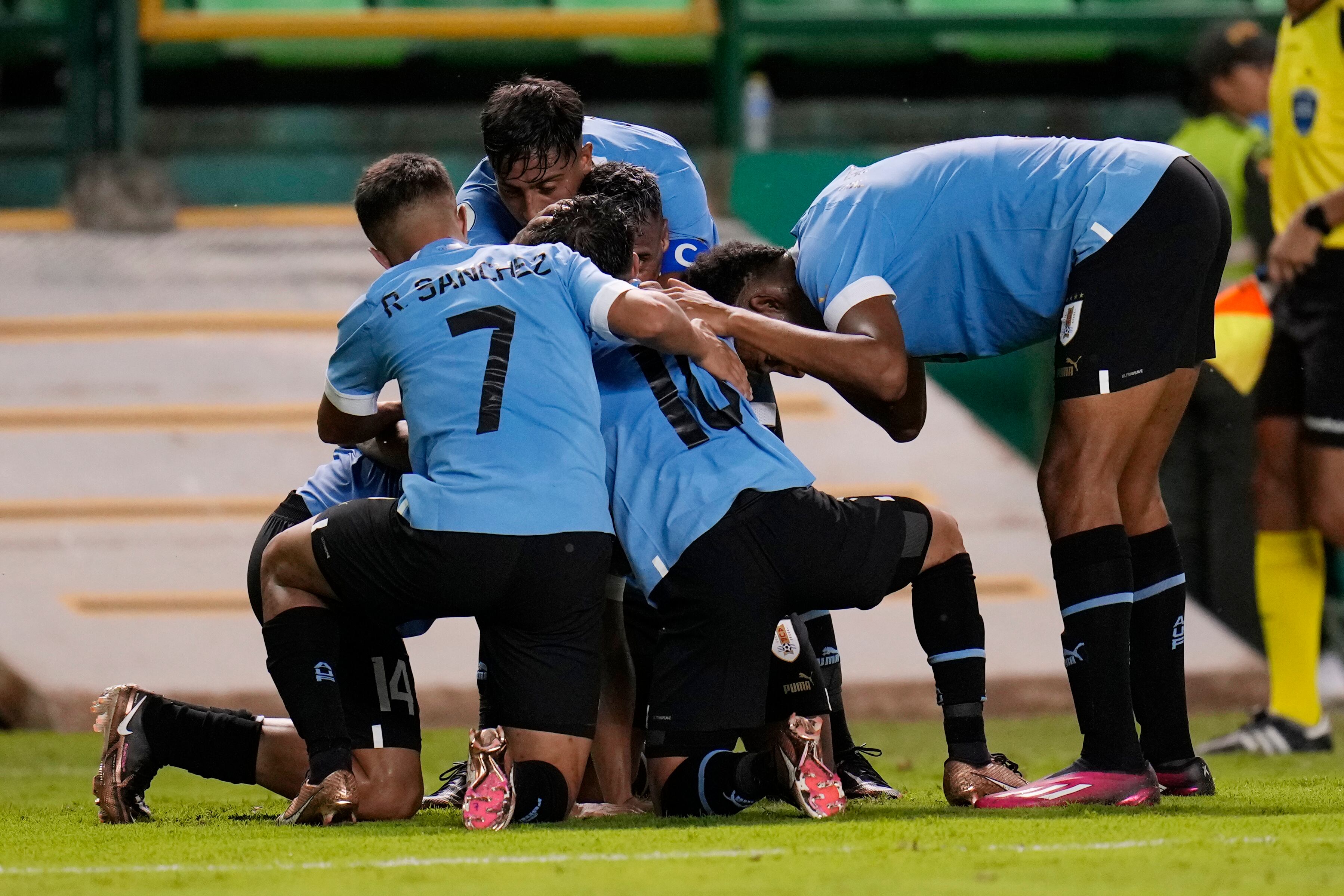Uruguay's players congratulated their teammate Sergio Garcia he scored his side's third goal during a South America U-20 Championship soccer match against Chile, in Palmira, Colombia, Sunday, Jan. 22, 2023. (AP Photo/Fernando Vergara)