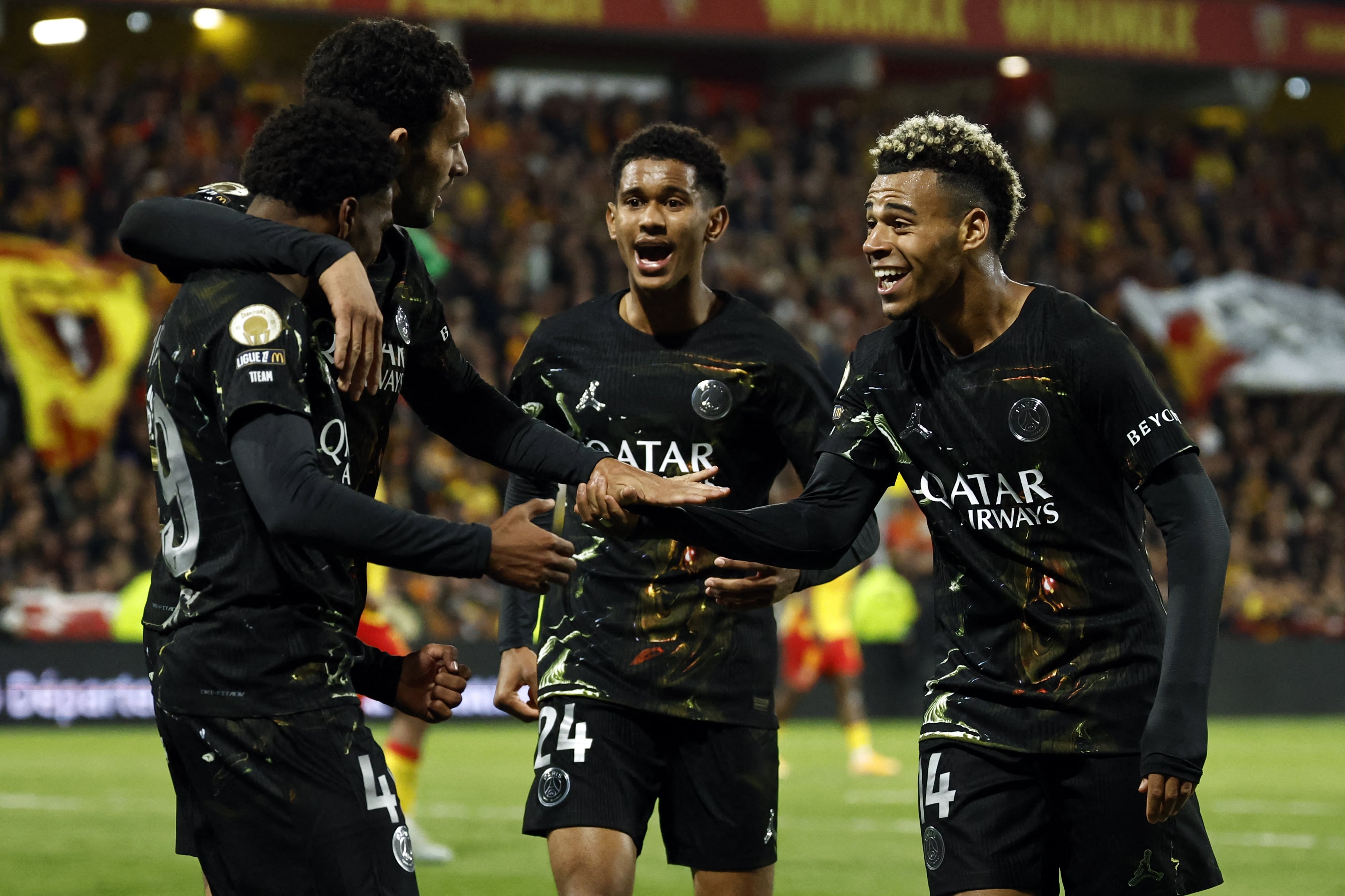 El delantero francés del Paris Saint-Germain, Ibrahim Mbaye (izq.), número 49, es felicitado por sus compañeros tras marcar un gol durante el partido de la Ligue 1 francesa entre el RC Lens y el Paris Saint-Germain (PSG) en el estadio Bollaert-Delelis de Lens, el 13 de mayo de 2026. (Foto de SIMON WOHLFAHRT / AFP)