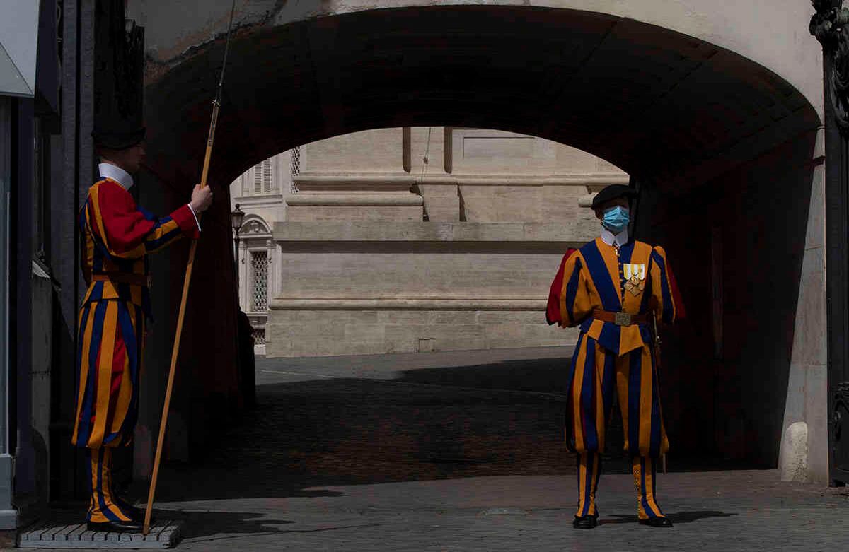 Guardias suizos con una máscara facial para evitar la propagación de covid-19 patrullan el Arco delle Campane, en la Plaza de San Pedro en el Vaticano el día de la reapertura de la Basílica de San Pedro, el lunes 18 de mayo de 2020. Italia está lentamente levantando las restricciones sanitarias después de un bloqueo por el coronavirus de dos meses. (Foto AP / Alessandra Tarantino)