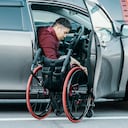 Paraplegic man in a wheelchair getting in or out of his car in Japan