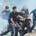 F09 En medio de nubes de gas lacrimógeno, agentes de policía vestidos de civil detienen a manifestantes durante una manifestación en Yakarta. Foto: AP / Tatan Syuflana