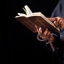 Pastor reads the Bible.The cross in the Pastor hand