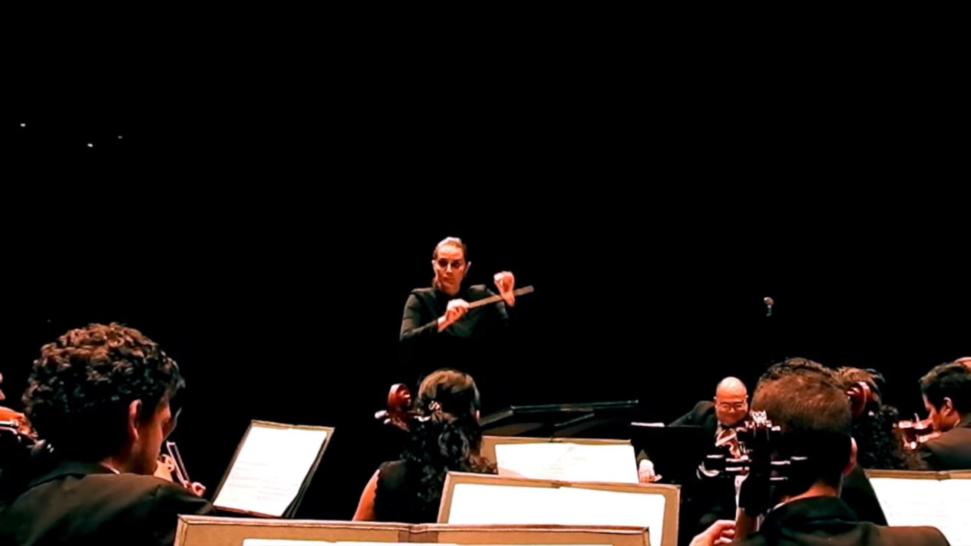 Lina González dirigiendo la orquesta.