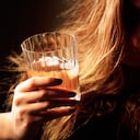Una mujer con dolor de cabeza por consumo de alcohol