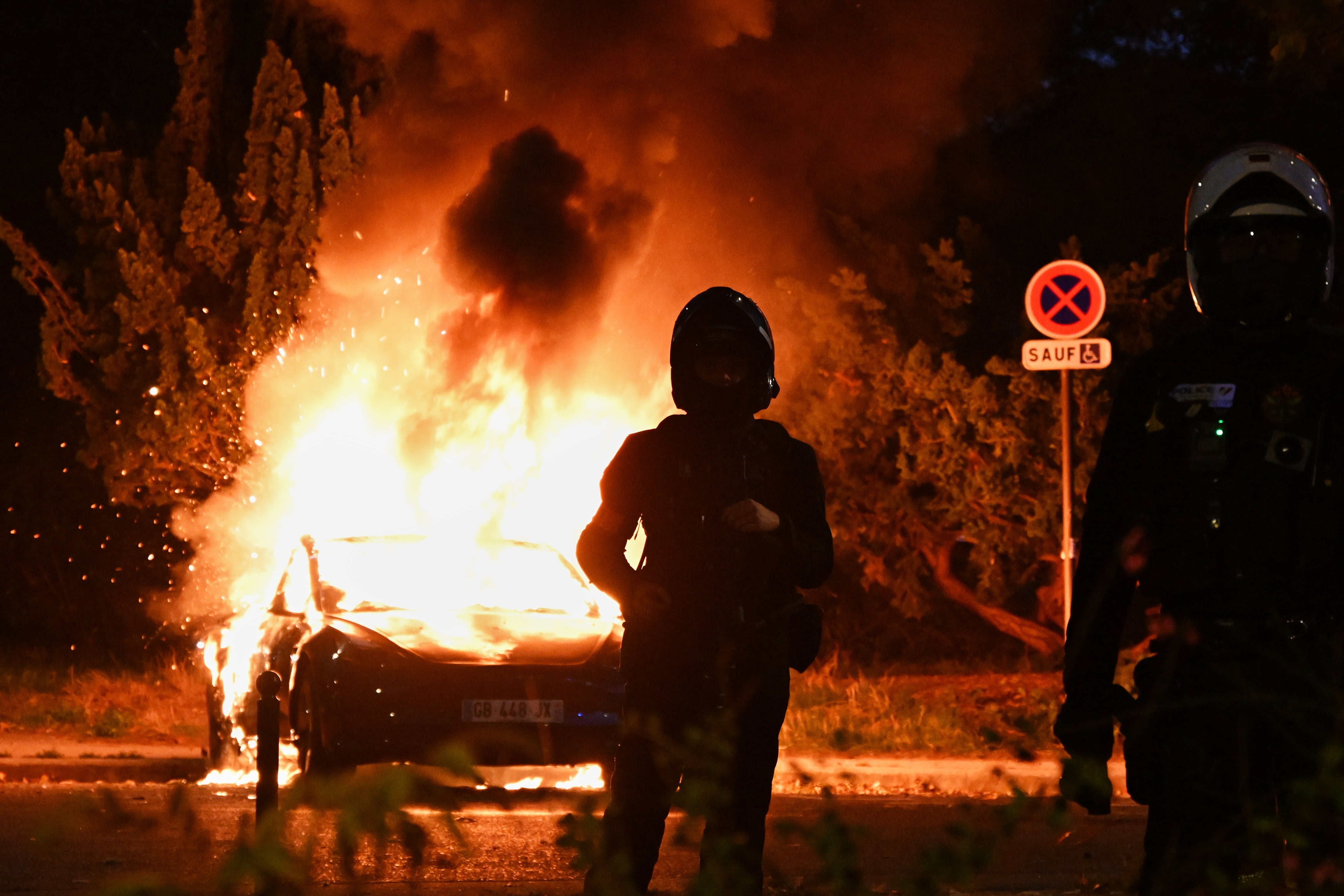 Un automóvil arde durante unas protestas por el costo de vida y la educación en París, Francia.