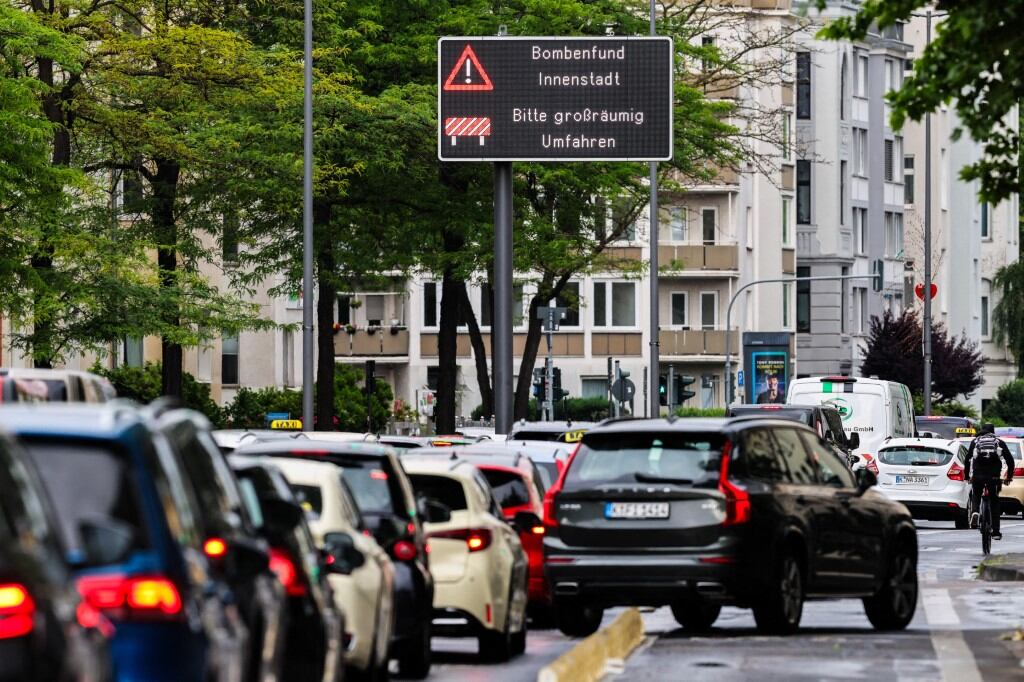 4 de junio de 2025, Renania del Norte-Westfalia, Colonia: Los usuarios de la carretera son informados sobre la desactivación de bombas en un cartel en el centro de la ciudad, mientras que en la Riehler Straße se ha formado un atasco. El 02.06.2025 se descubrieron en el distrito de Deutz tres bombas de la Segunda Guerra Mundial que serán desactivadas el 04.06.2025. Foto: Christoph Reichwein/dpa (Foto de Christoph Reichwein / dpa Picture-Alliance vía AFP)
