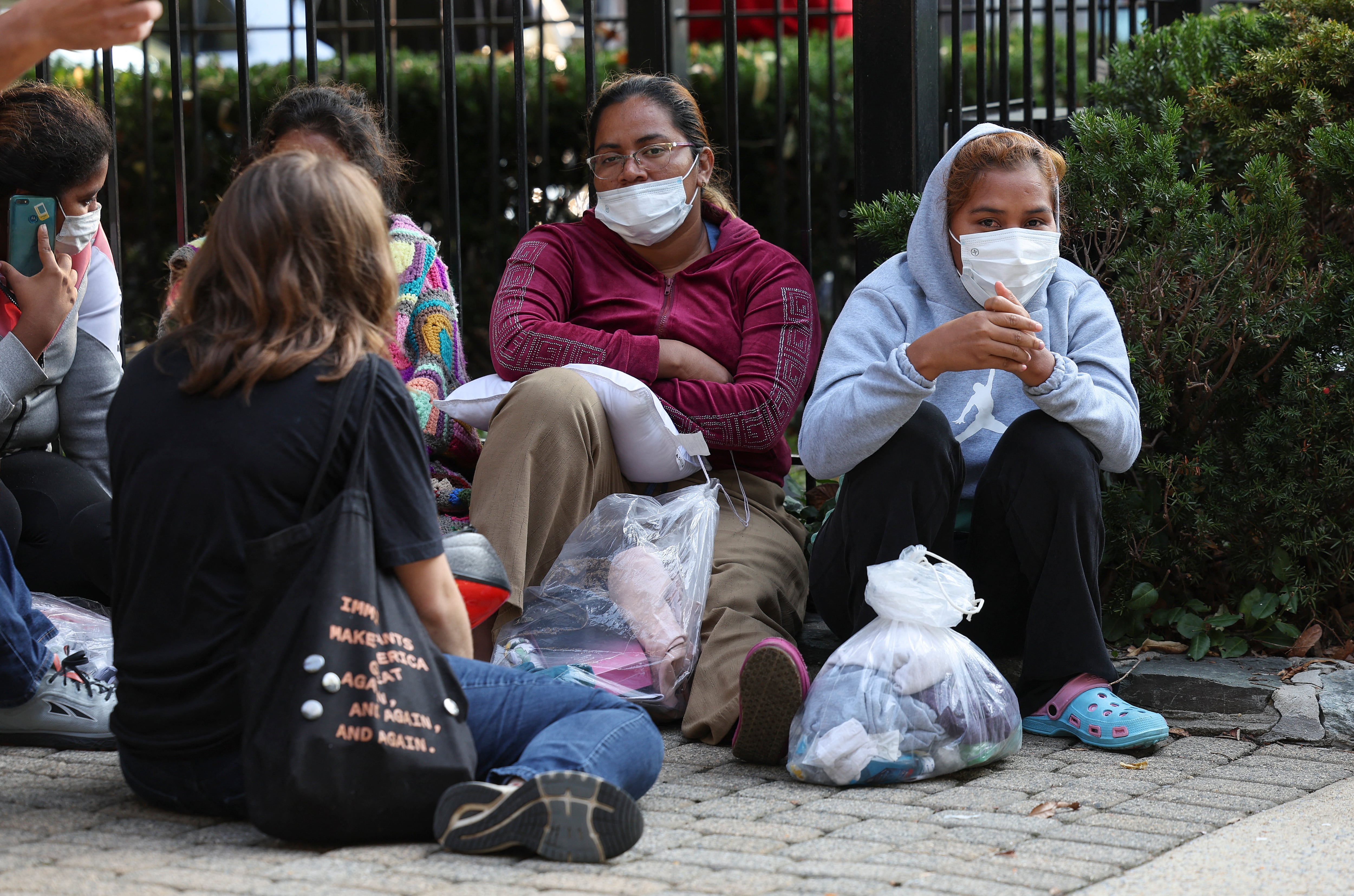 Migrantes de América Central y del Sur esperan cerca de la residencia de la vicepresidenta de EE. UU. Kamala Harris después de ser dejados el 15 de septiembre de 2022 en Washington, DC. El gobernador de Texas, Greg Abbott, envió autobuses que transportaban inmigrantes desde la frontera sur hasta la casa de Harris la madrugada del jueves. Kevin Dietsch/Getty Images/AFP (Foto de Kevin Dietsch/GETTY IMAGES NORTH AMERICA/Getty Images vía AFP)