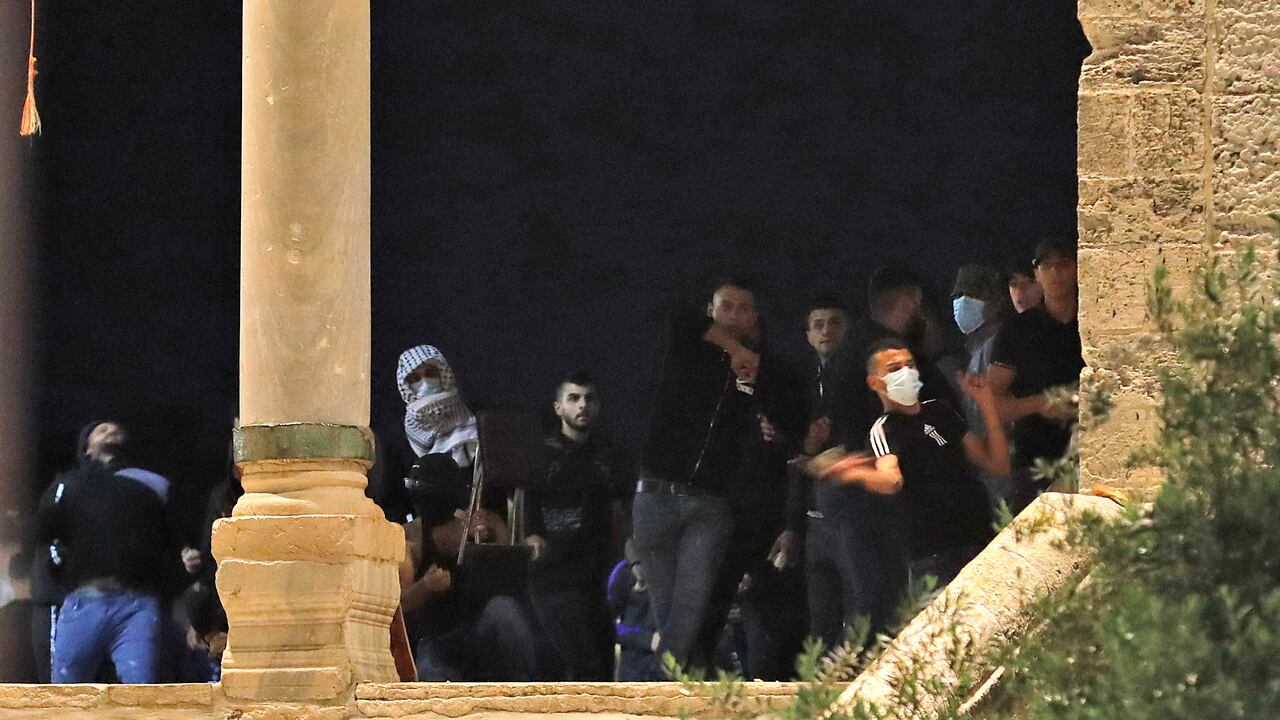 Los manifestantes palestinos arrojan piedras durante los enfrentamientos con las fuerzas de seguridad israelíes en el complejo de la mezquita de al-Aqsa en Jerusalén, el 7 de mayo de 2021. (Photo by Ahmad GHARABLI / AFP)