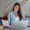 Mujer latinoamericana pagando facturas en línea en casa usando una computadora portátil - conceptos de tecnología. Recibos.