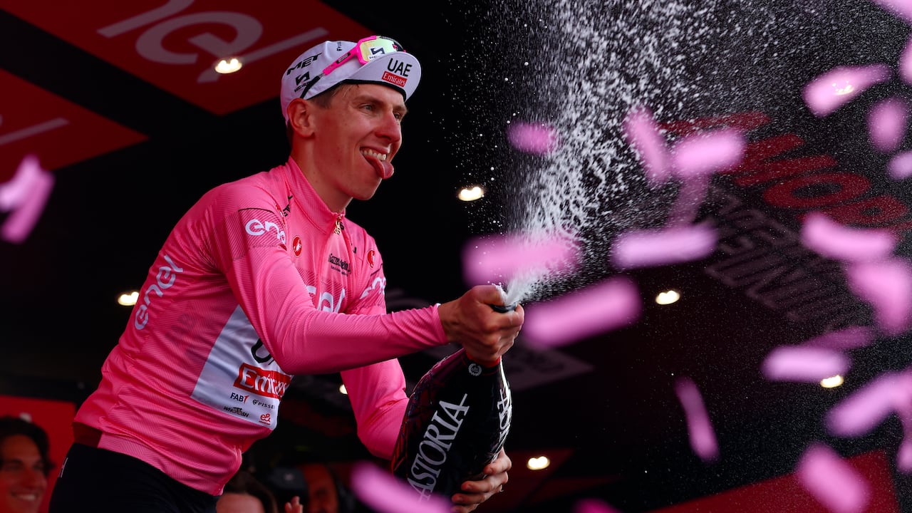 Team UAE's Slovenian rider Tadej Pogacar celebrates the overall leader's pink jersey on the podium of the 11th stage of the 107th Giro d'Italia cycling race, 207km between Foiano di Val Fortore and Franca Villa al Mare, on May 15, 2024. (Photo by Luca Bettini / AFP)