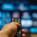 An adult man enjoying his Saturday night alone, watching TV in his living room